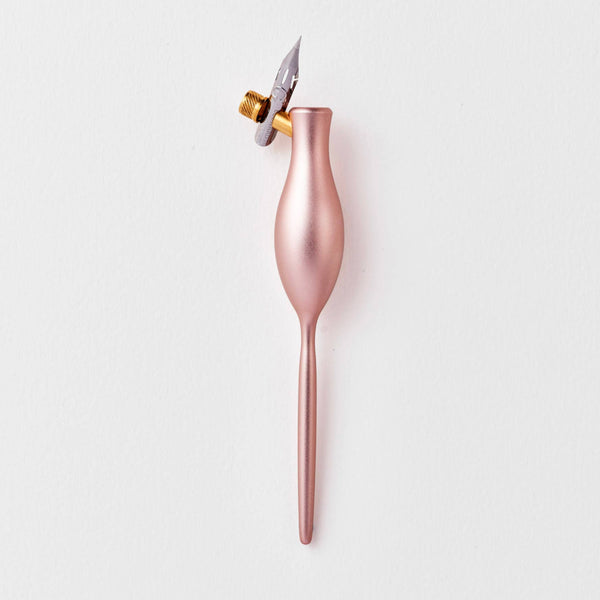Rose gold calligraphy dip pen on a white background