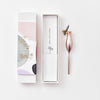 Rose gold pen with packaging on a white background