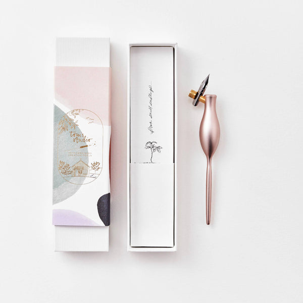 Rose gold pen with packaging on a white background