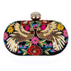 Decorative clutch bag with floral and bird design on a white background