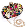 Decorative clutch bag with floral and bird design on a white background