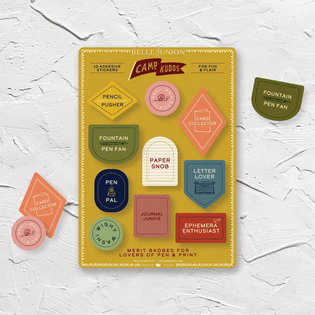 Pack of adhesive stickers with colorful merit badge stickers on a white textured background