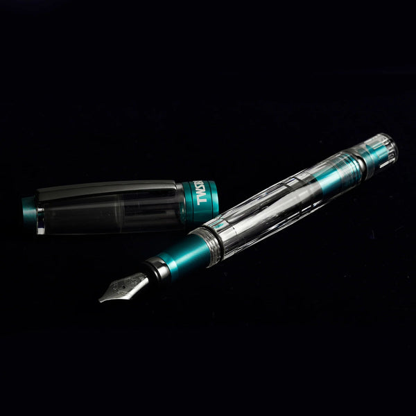 Fountain pen with transparent body and teal accents on a black background