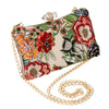 Floral patterned clutch bag with gold chain strap on a white background