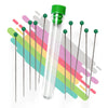 A set of stainless steel cleaning pins with green caps, displayed in front of a colorful background, and packaged in a clear plastic tube.