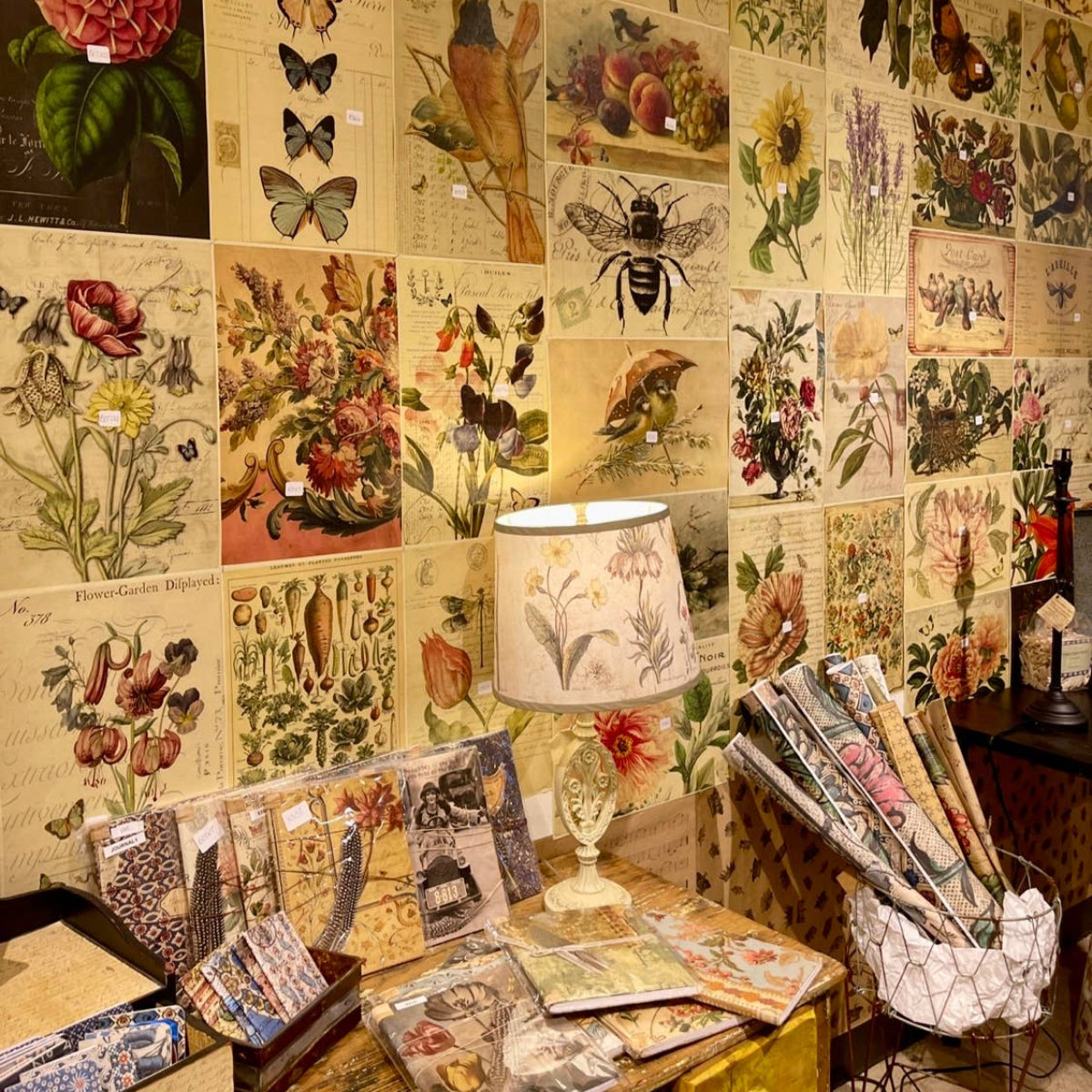 Wall with vintage-style botanical prints and a table displaying similar items.