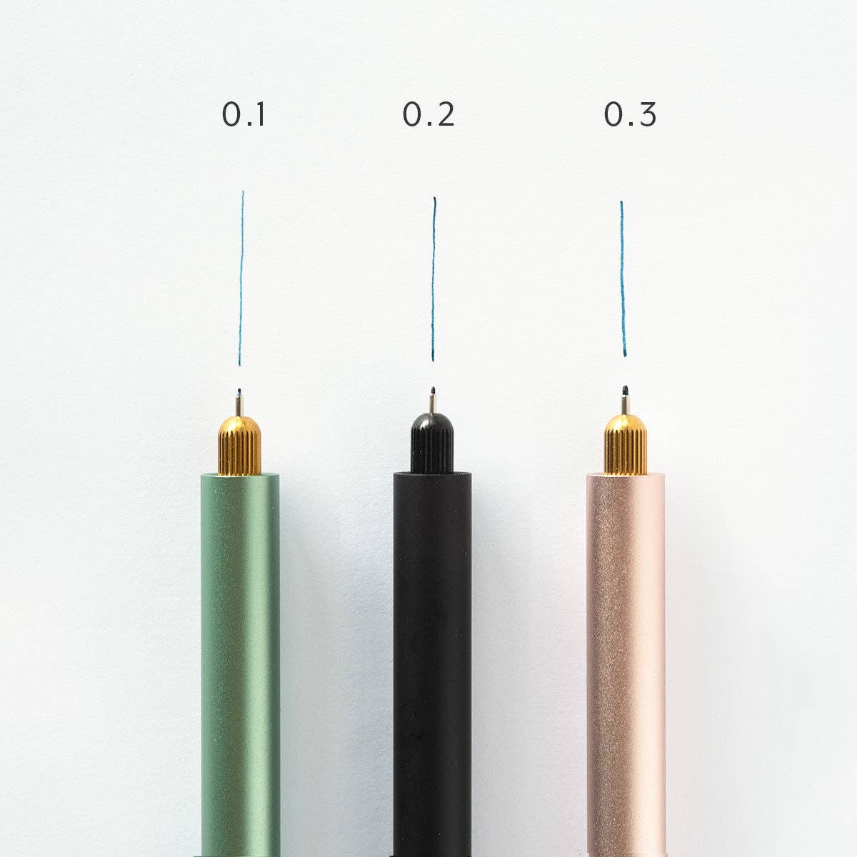 Three cylindrical pens with different colored tips on a white background