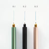 Three cylindrical pens with different colored tips on a white background