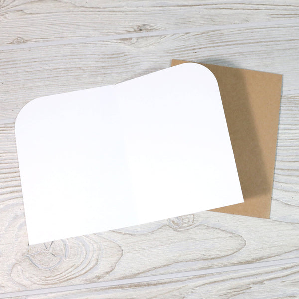 White card with brown envelope on a wooden surface