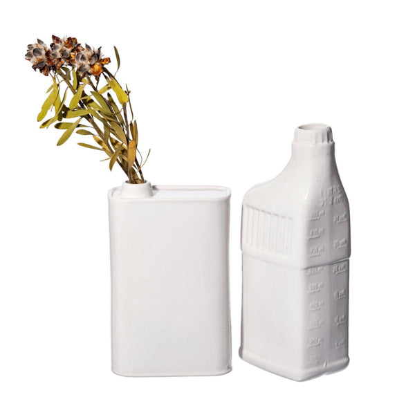 Two white ceramic vases, one with dried flowers, on a white background