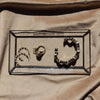 Jewelry set including a necklace, ring, and earrings displayed in a clear box on a beige fabric background.