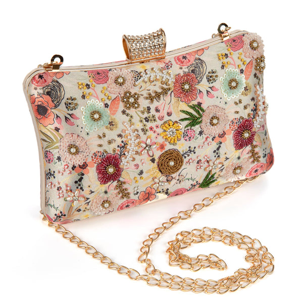 Floral patterned clutch bag with gold chain strap on a white background