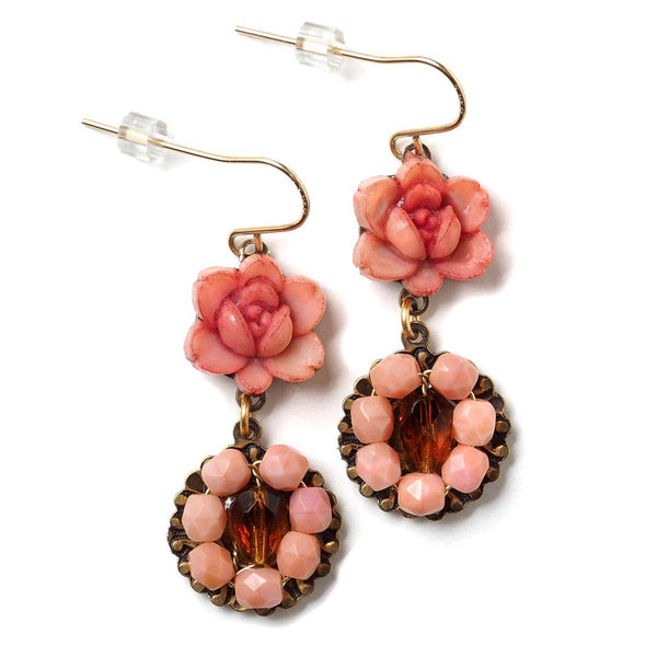 Pink floral earrings with brown accents on a white background