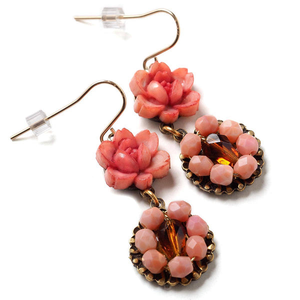 Pink floral earrings with gold accents on a white background