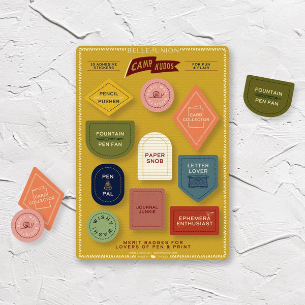 Pack of adhesive stickers with colorful merit badge stickers on a white textured background