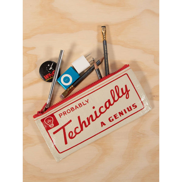 A cream canvas zippered pencil case with red trim and red lettering that reads 'PROBABLY Technically A GENIUS', shown on a light wood background with art supplies peeking out from inside.