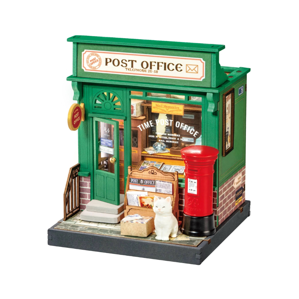 Model of a post office with a red mailbox and a cat on a white background