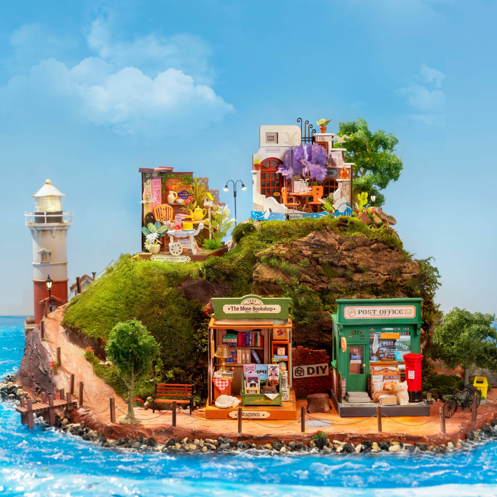 Miniature model of a coastal town with buildings, shops, and a lighthouse on an island.