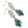 Pair of earrings with floral design and turquoise stones on a white background