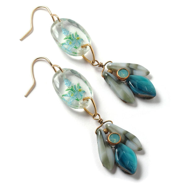 Pair of earrings with floral design and turquoise stones on a white background