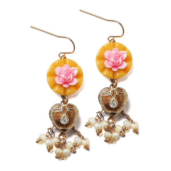 Ornate earrings with pink floral elements and heart-shaped charms on a white background