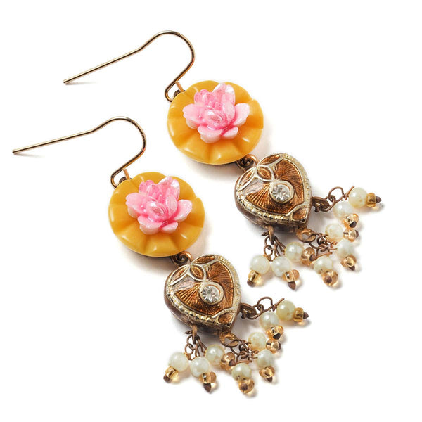 Decorative earrings with floral and heart designs on a white background