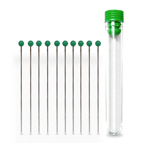 Set of stainless steel pins with green handles in a clear tube on a white background