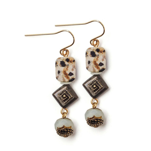 Pair of earrings with square and round beads on a white background