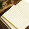 Open notebook with lined pages on a wooden surface