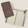 Brown leather notebook with gold accents on a light beige background