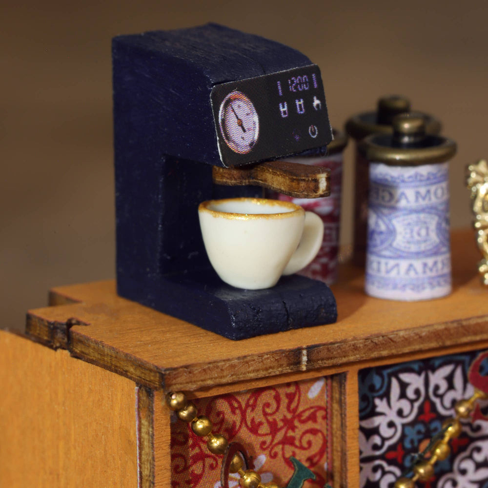 Miniature coffee machine with a cup on a wooden surface