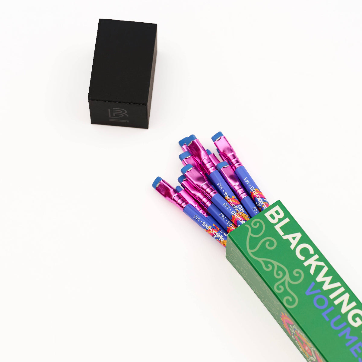 A set of colorful Blackwing Volume 1-1000 pen-style products fanned out from a green box, with a small black branded box placed above on a clean white background.
