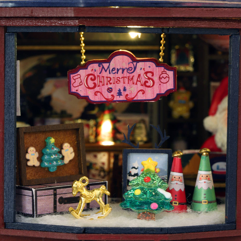 Miniature Christmas scene with decorative items and a 'Merry Christmas' sign.