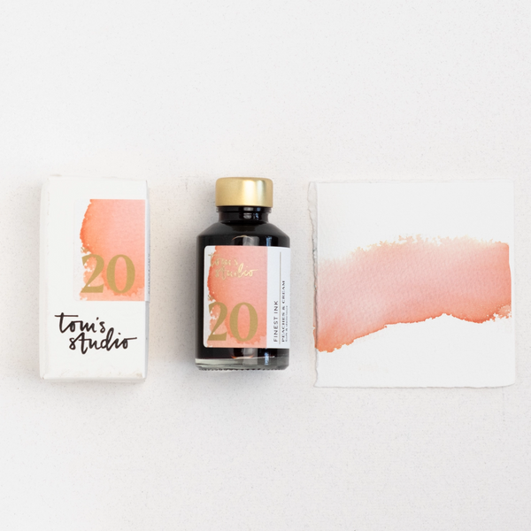 Bottle of ink with a label featuring '20' and 'Toni's Studio' on a white background