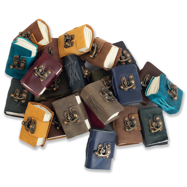 Collection of small, colorful books with decorative clasps on a white background
