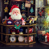 Miniature Santa Claus figure in a toy store setting with various toys and decorations.
