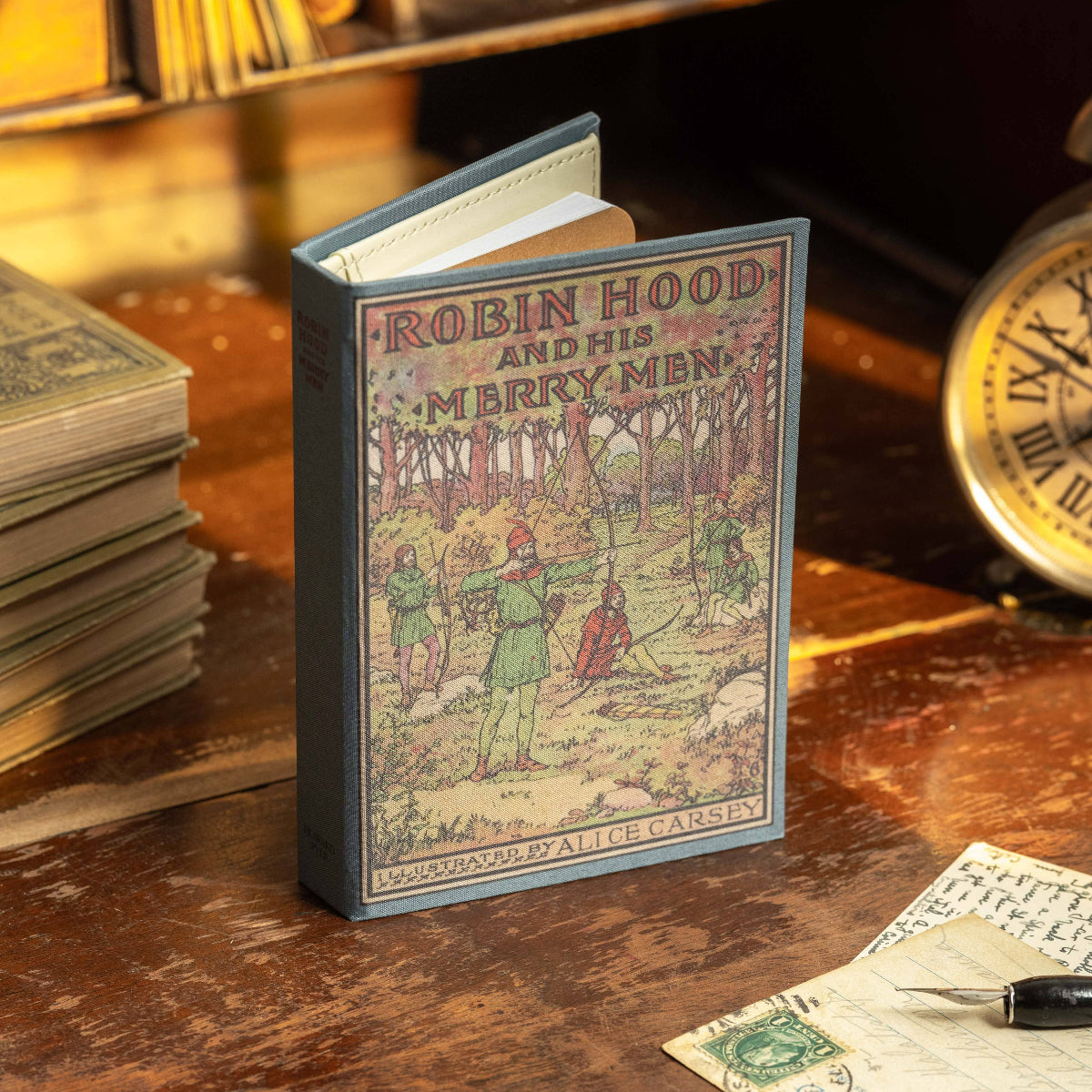 Miniature book titled 'Robin Hood and His Merry Men' on a wooden surface with vintage items.