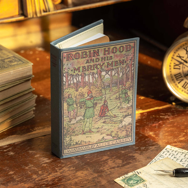 Miniature book titled 'Robin Hood and His Merry Men' on a wooden surface with vintage items.